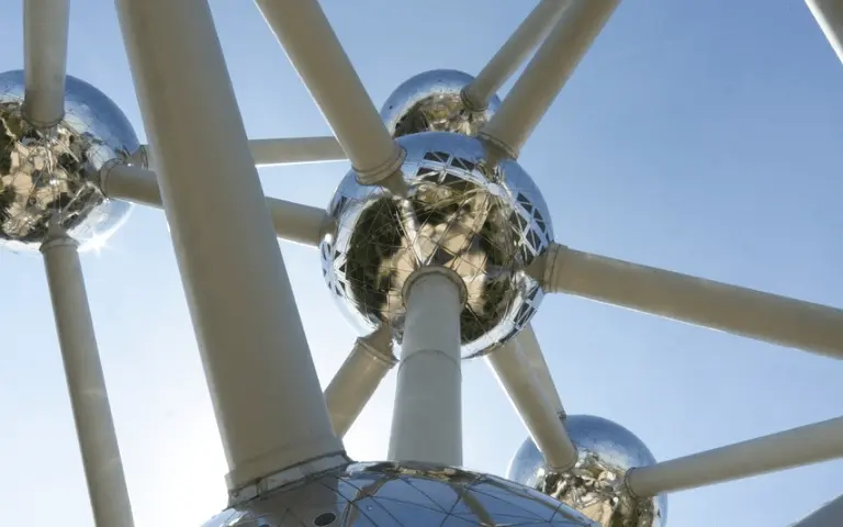 Une architecture en forme de structure moléculaire est photographiée en contre-plongée. C'est l'Atomium de Bruxelles.